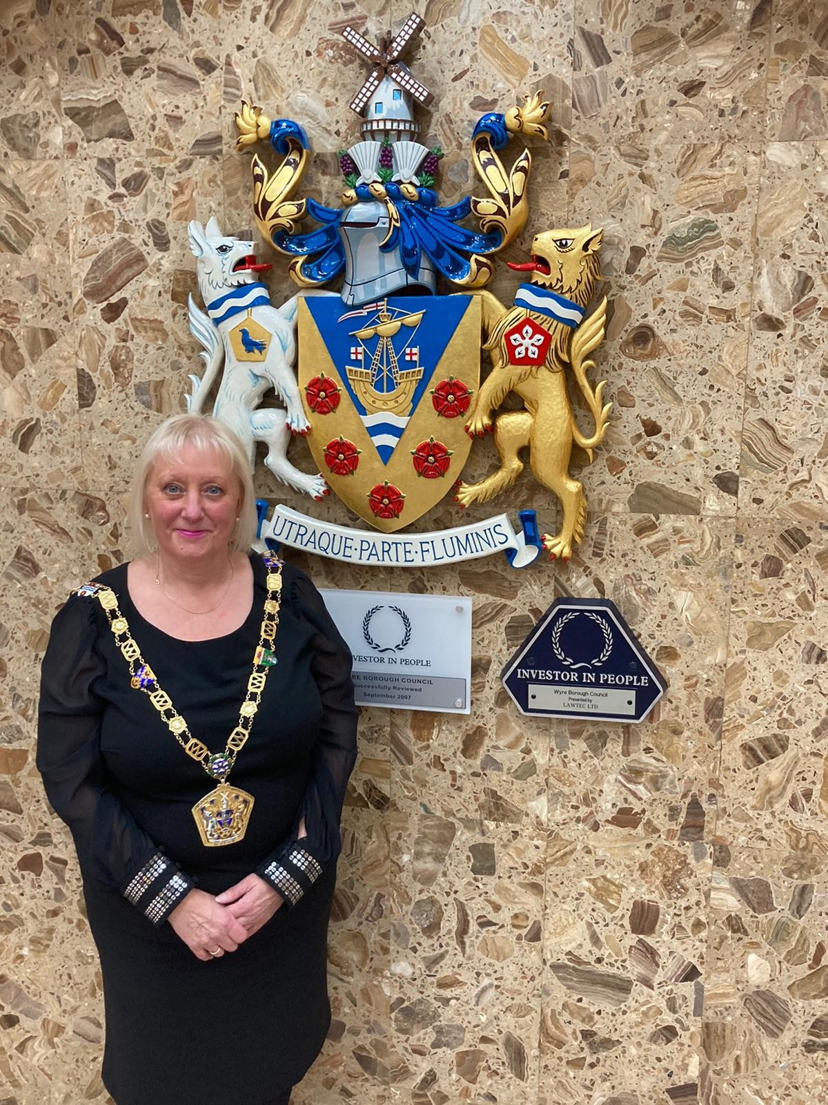Mayor Andrea Kay standing in front of the council crest in the civic centre reception