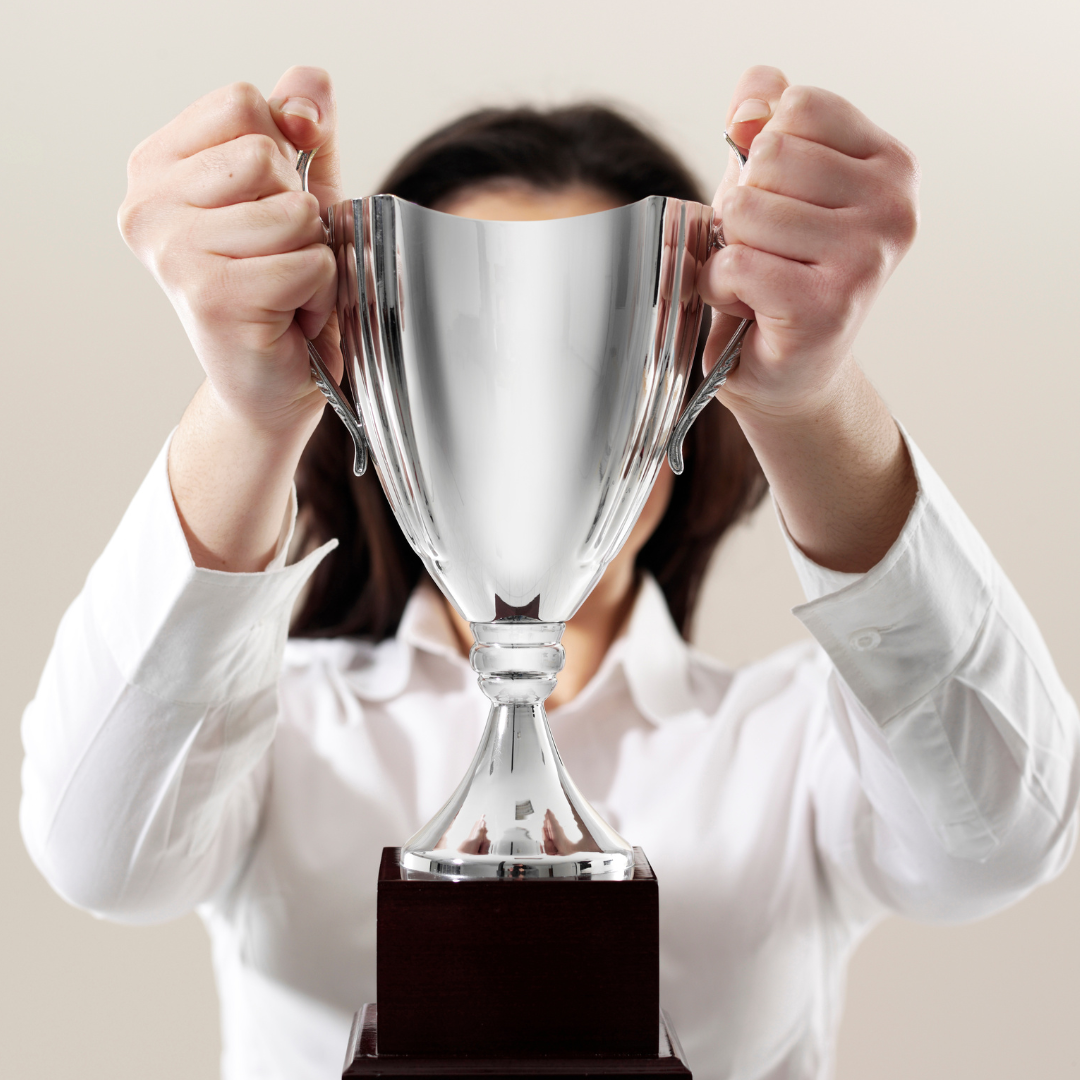 An image of a woman holding a trophy