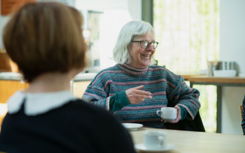 Two women chatting and smiling.