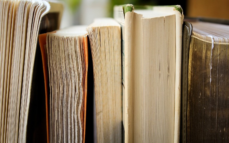 Old books on a shelf in a row.