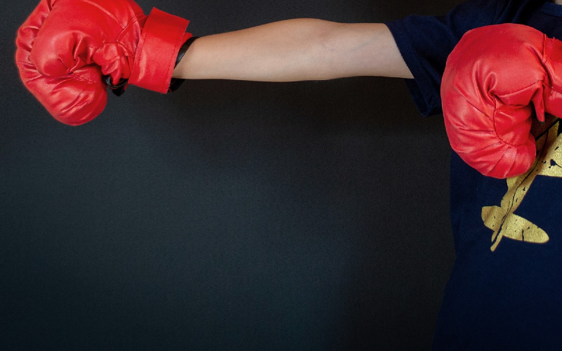 Young boy with red boxing gloves on.
