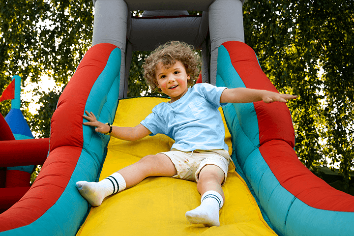 Child sliding down an inflatable slide.