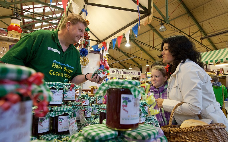 Family buying jam at Fleetwood Market stall.