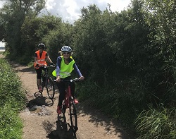 2 cyclists on a woodland path
