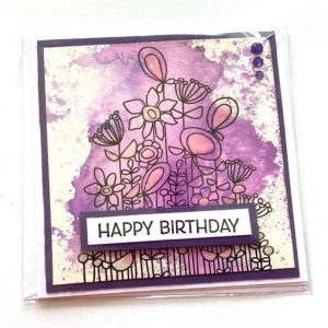 Happy Birthday card with purple watercolour background and black line art assortment of flowers.