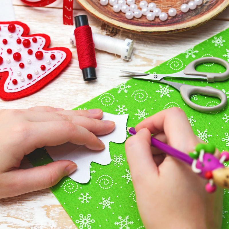 Childs hands creating a Christmas tree decoration