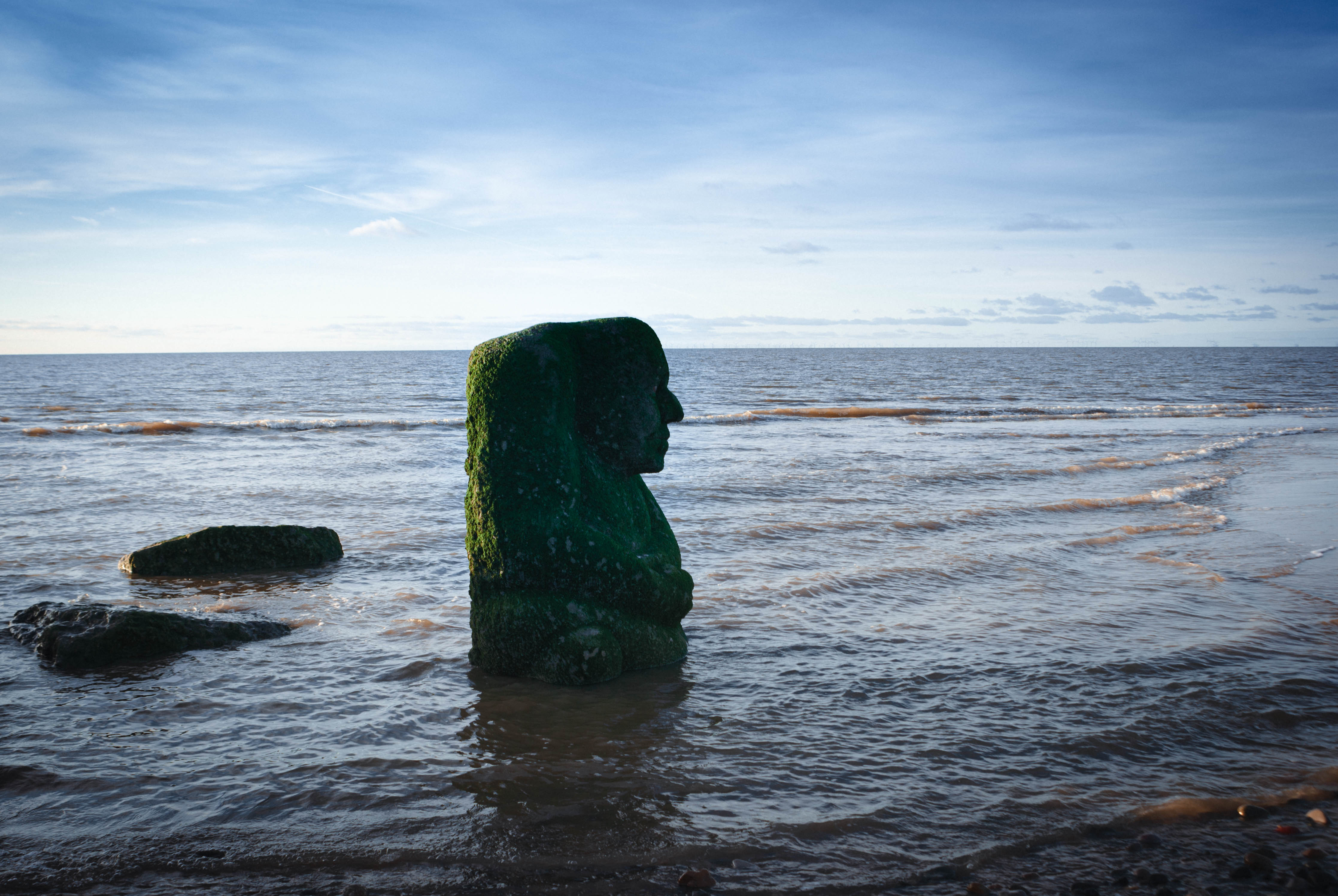 The beach at Cleveleys showing the sea and the sculpture of the sea ogre