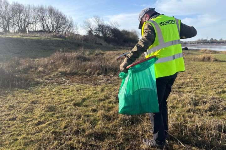 A person in a high-vis jacket litter picking
