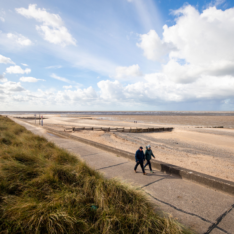 couple walking along Fleetwood prom