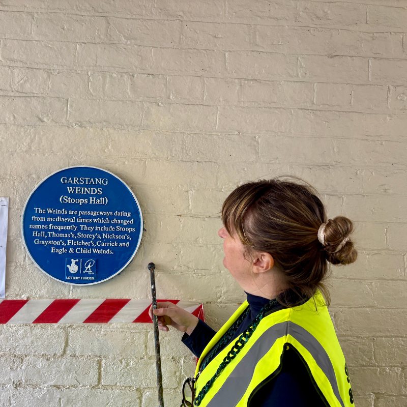 Lisa Wigham restoring a blue plaque