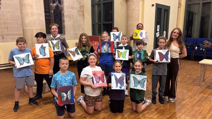 Children and young people holding up artwork showing butterflies.