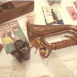 Artifacts from the past including a cornet, photographs and an old headlamp