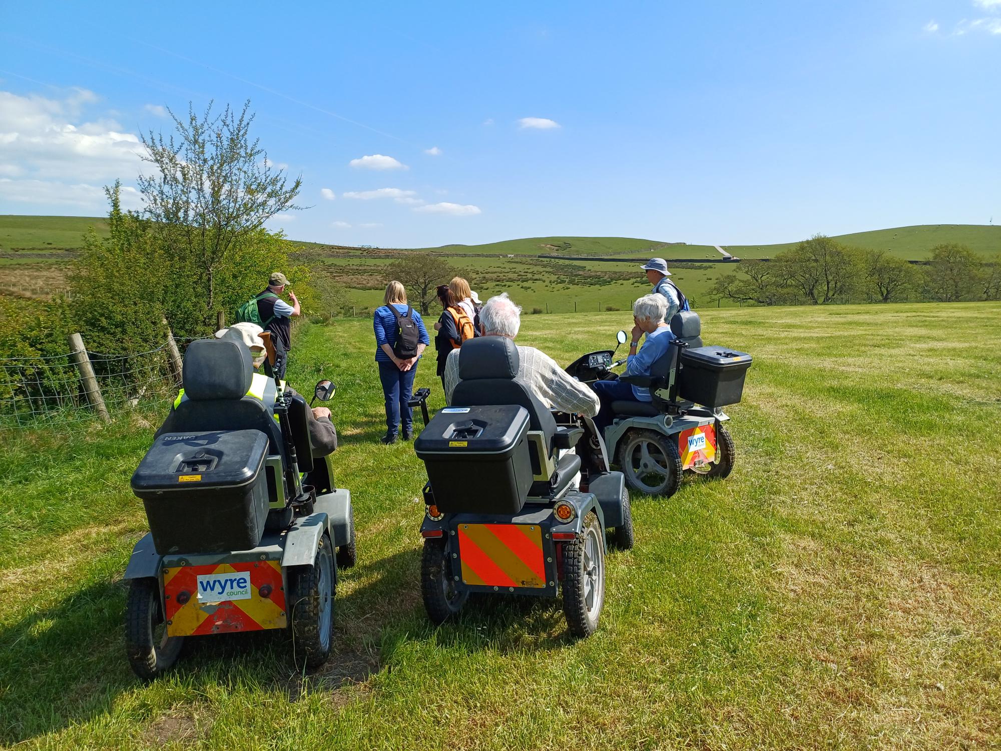 People using trampers and on feet going through countryside