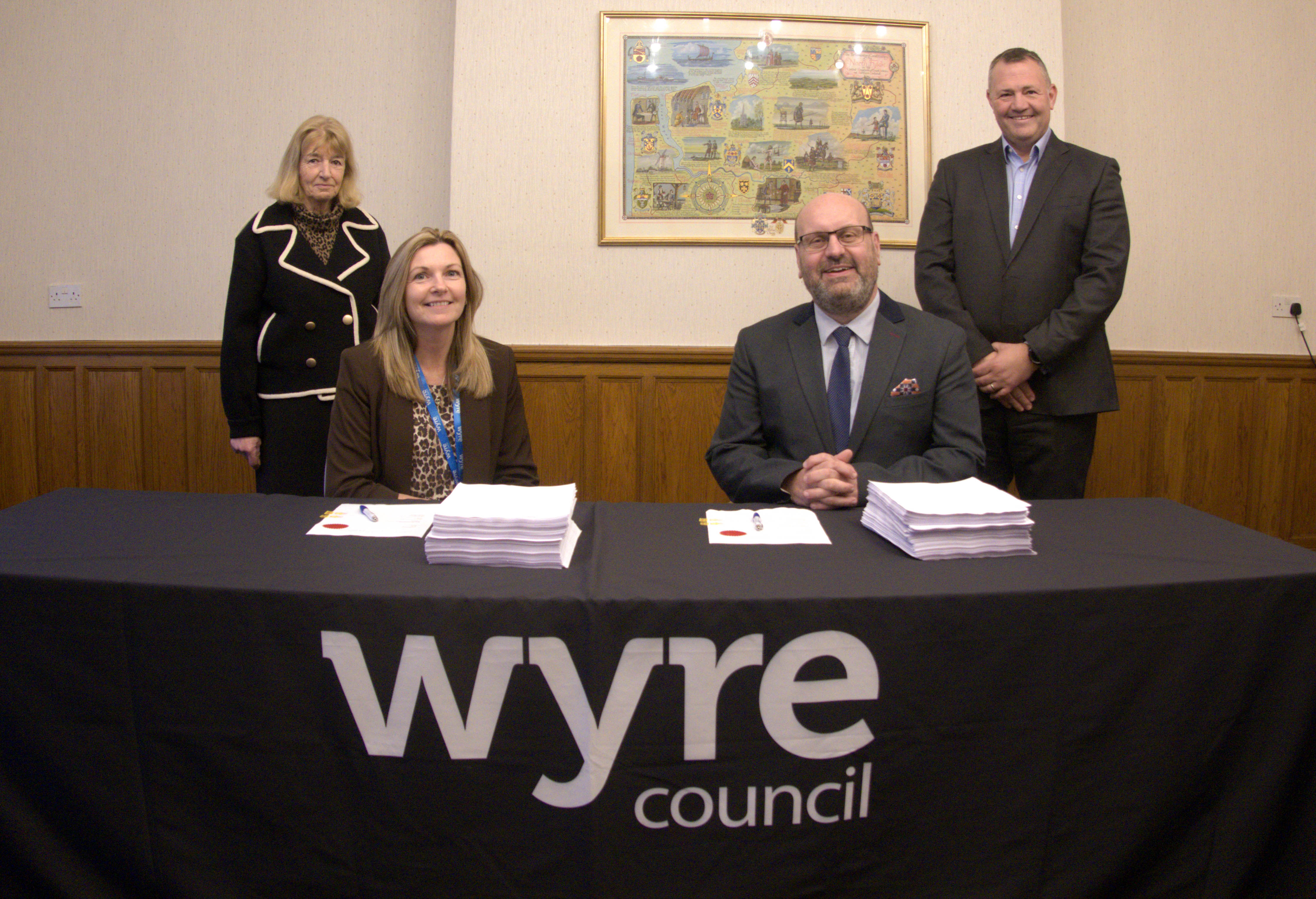 An image of wyre councillors and officers and Parkwood Leisure officers sat at a table signing a contract
