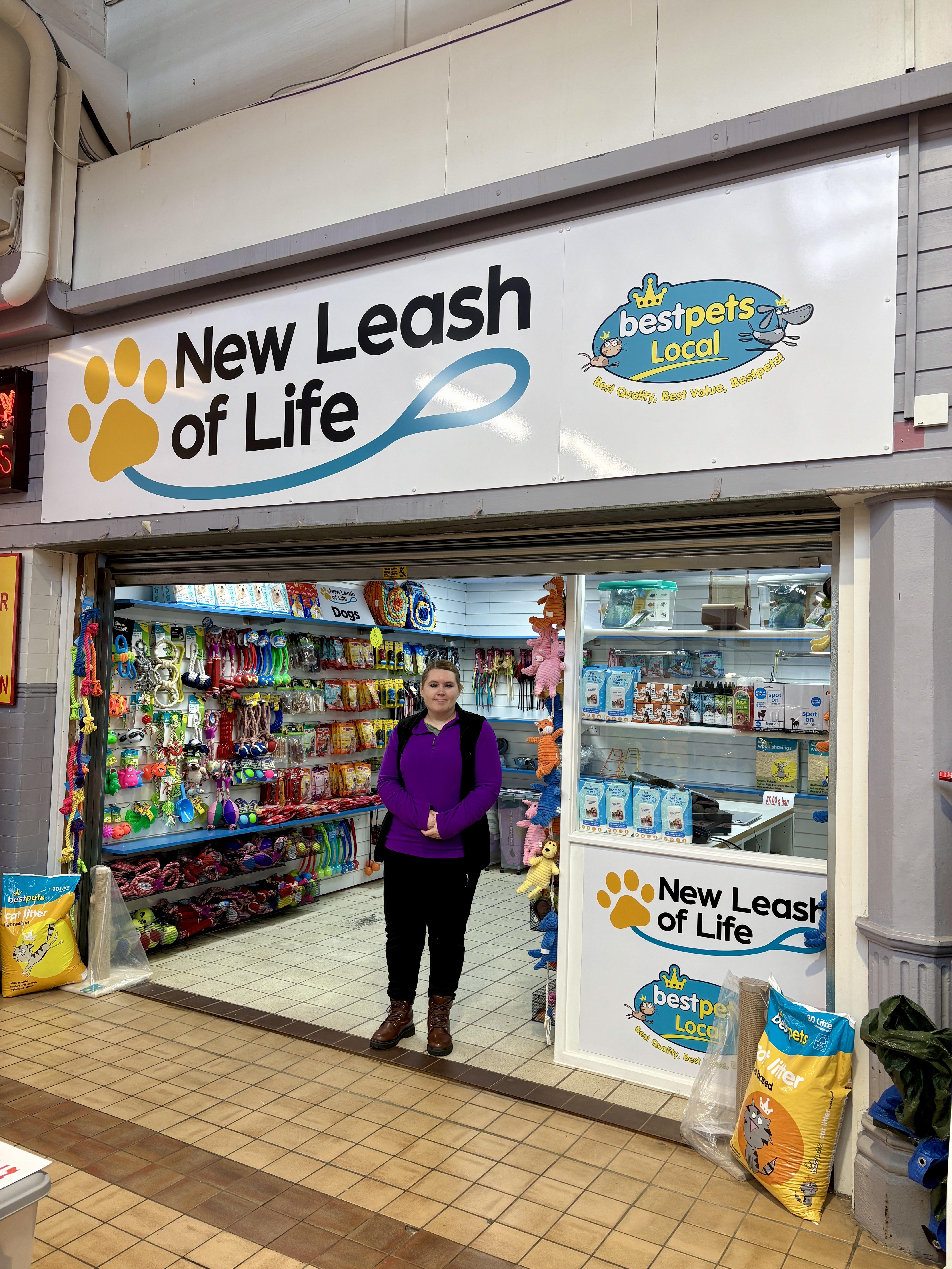 A stall holder stands in front of her pitch a New Leash of Life
