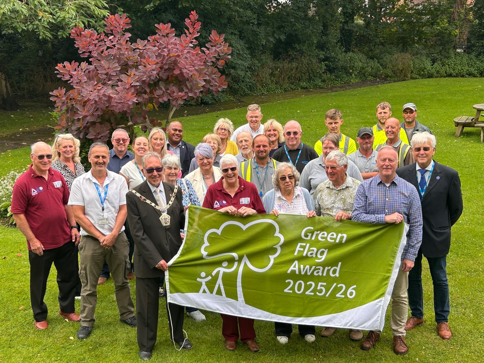 Green Flag Award 2025 group of volunteers and park workers with banner