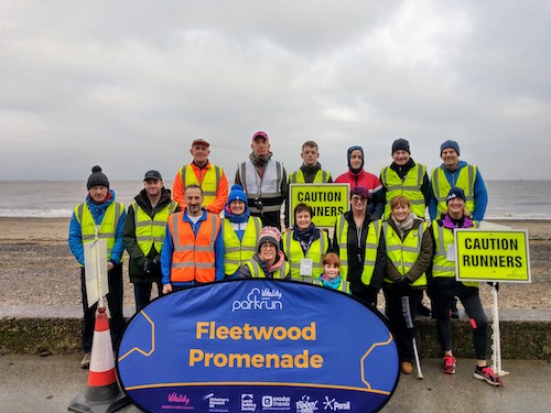 Park run volunteers in a group on the promenade