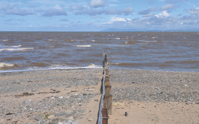 Rossall Point beach and sea on sunny day.