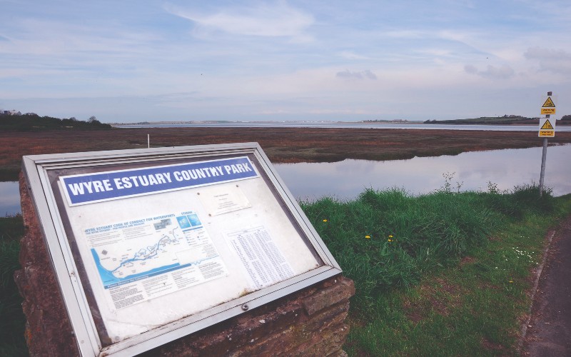 View of Wyre Estuary with signboard in foreground.
