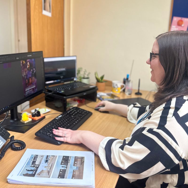 Steph working on a graphics project at her desk in office.