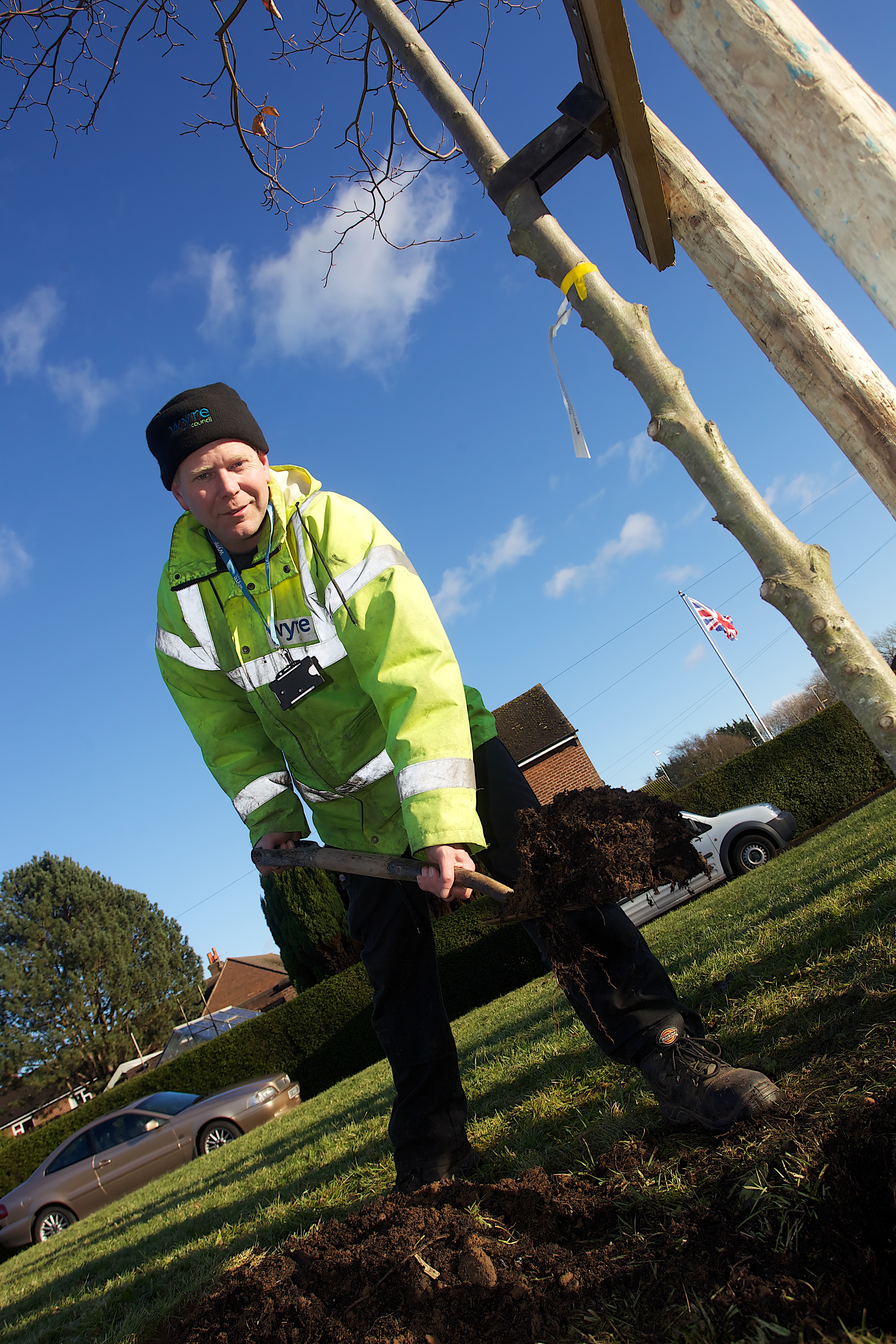Man in high viz planting a tree