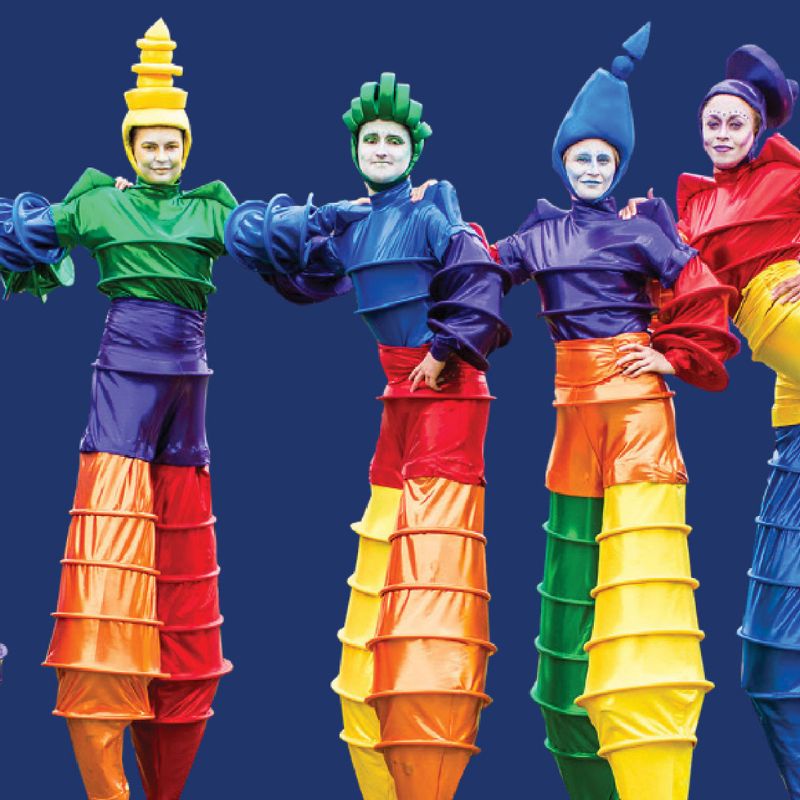 Stilt walkers in colourful costumes posing for camera.