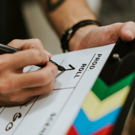 Person filling out details on a clapper board