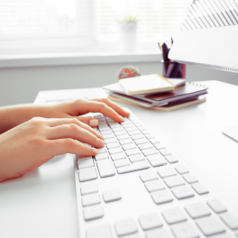 Hands of office worker on keyboard typing