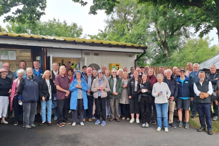 A crowd of people posing and smiling for the camera. These are our volunteers who work at our Estuary Country Park.