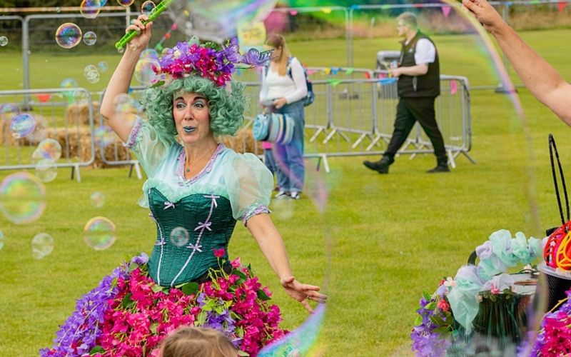 A woman creating bubbles at Wanderland's Family Festival.