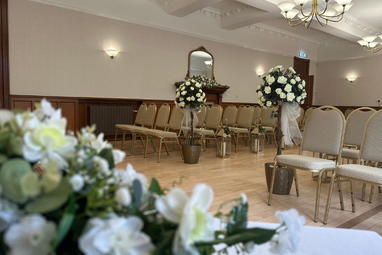 Civic Centre Members Lounge during a wedding. There's rows of seats either side of an isle.