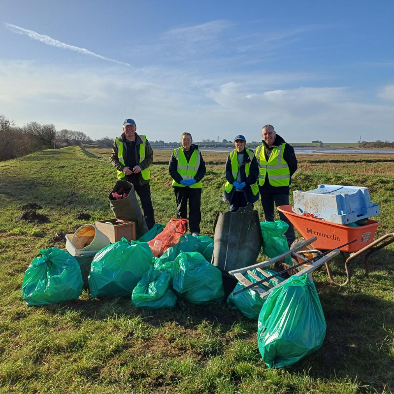 Group of people with green big bags of rubbish collected