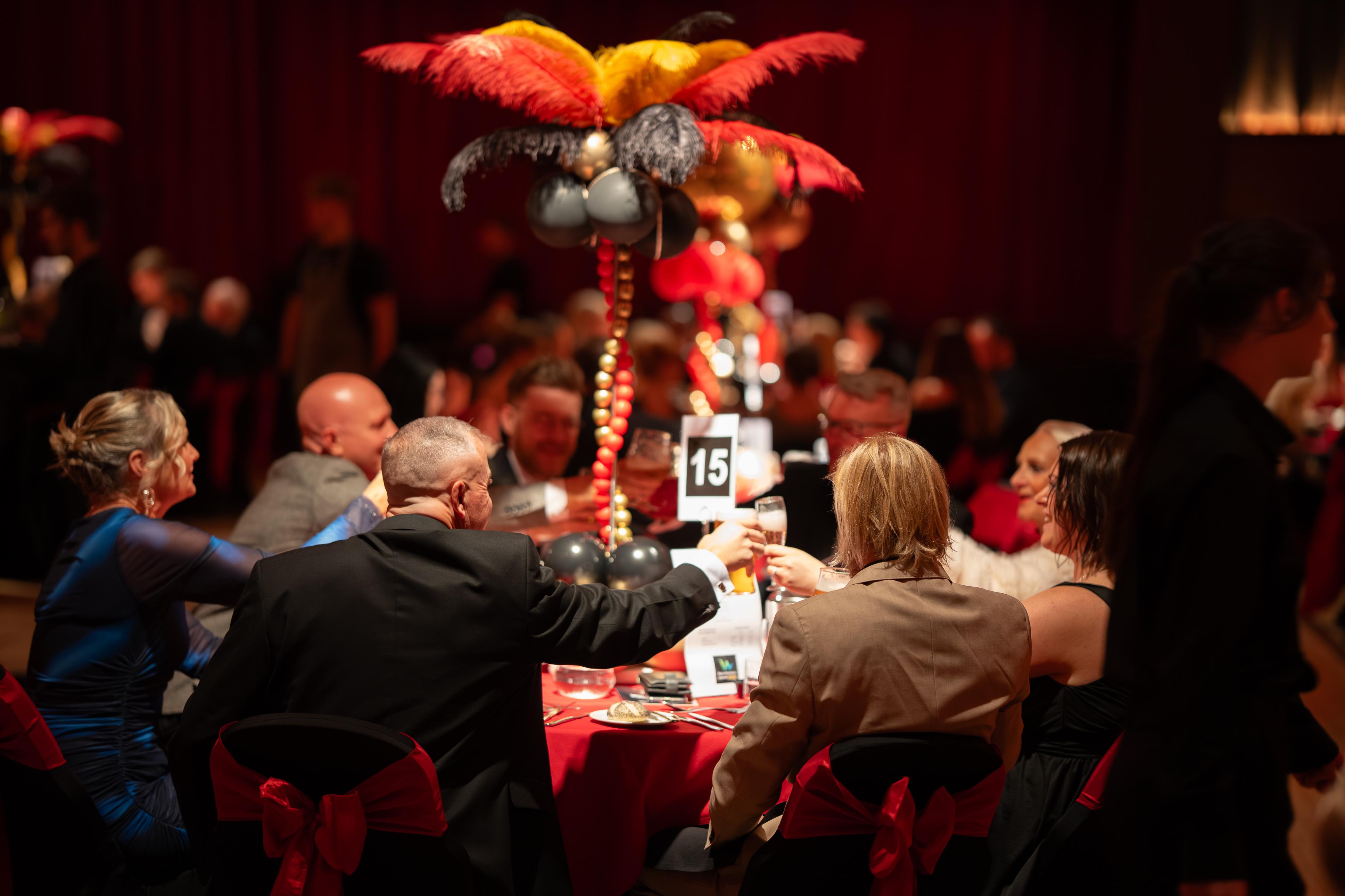 People celebrate at a round table clinking glasses