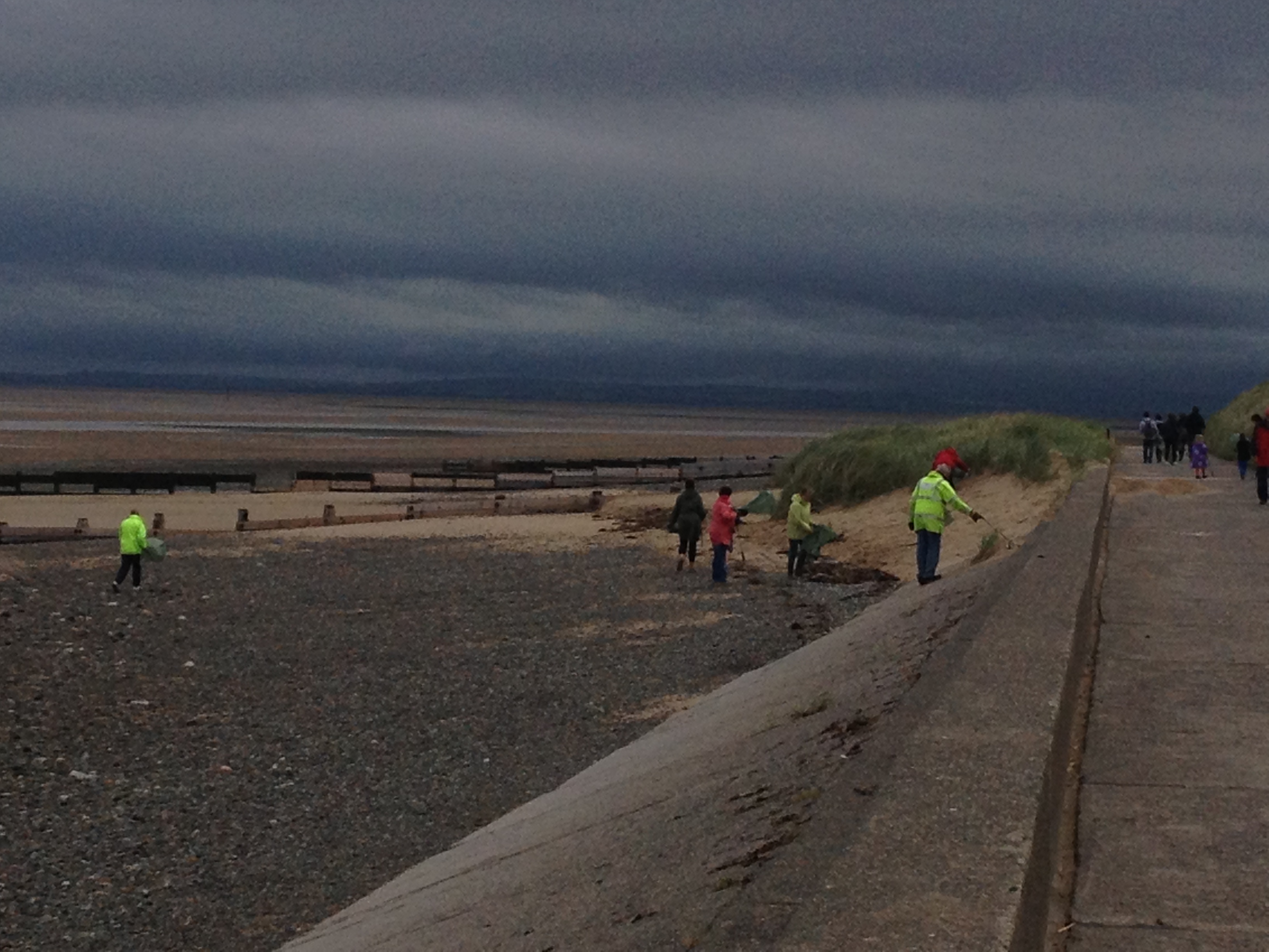 Beach cleaning team on the beach in stormy weather