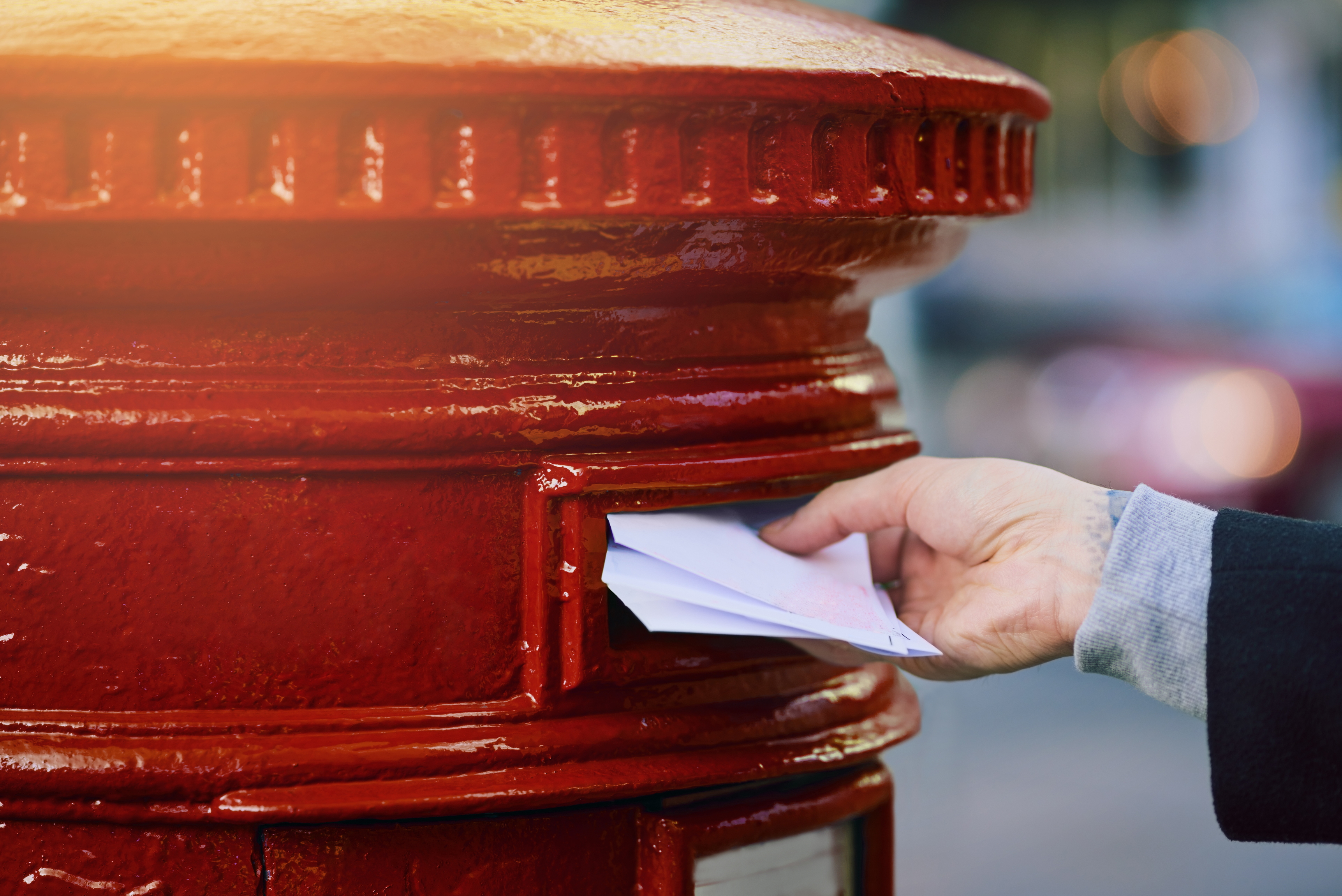 Hand posting letters into postbox
