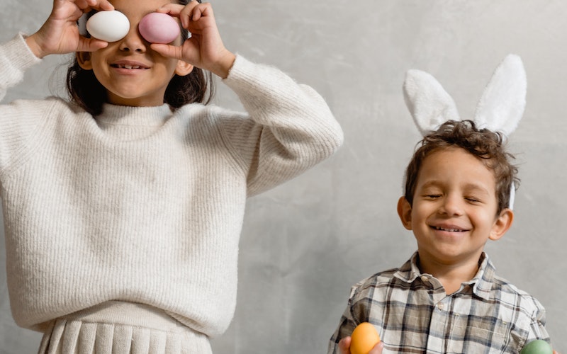 Young boy and girl wearing bunny ears and smiling for camera.
