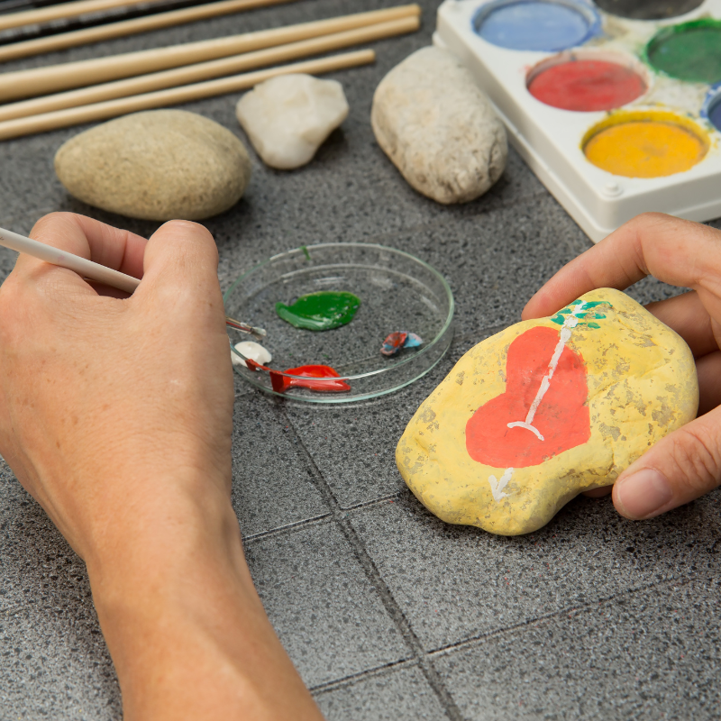 Hand painting stones with paint