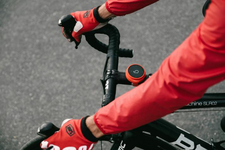 Close up of hands holing the handlebars of a bike.