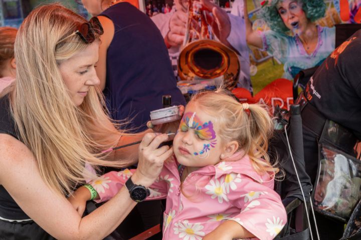 A child having their facepainted.