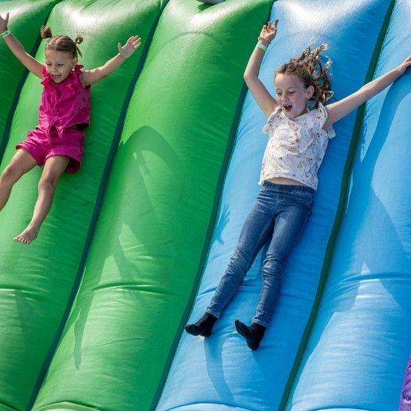Children sliding down a large inflatable slide.