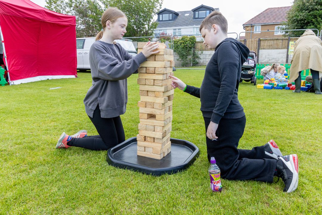 Two children playing with a large Jenga set